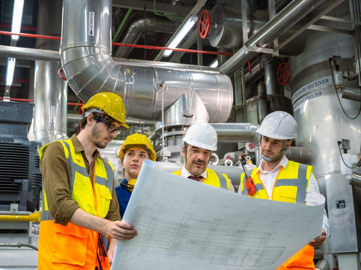 Engineers reviewing blueprints for plant room