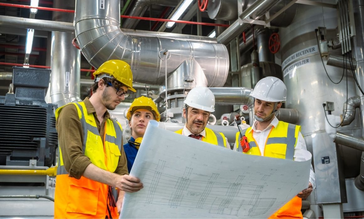 Engineers reviewing blueprints for plant room