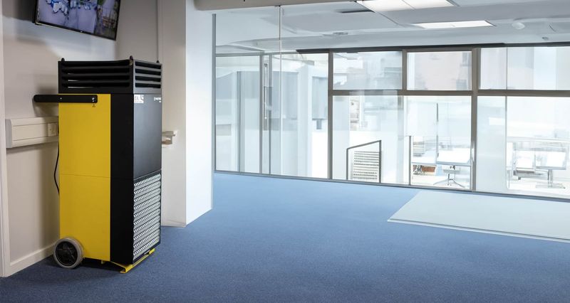 Commercial Trotec portable HEPA air purifier unit deployed in a modern office space for quality air management